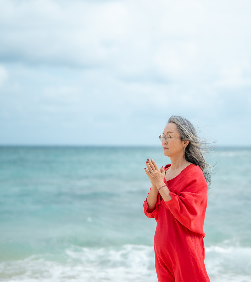 海辺で祈る女性